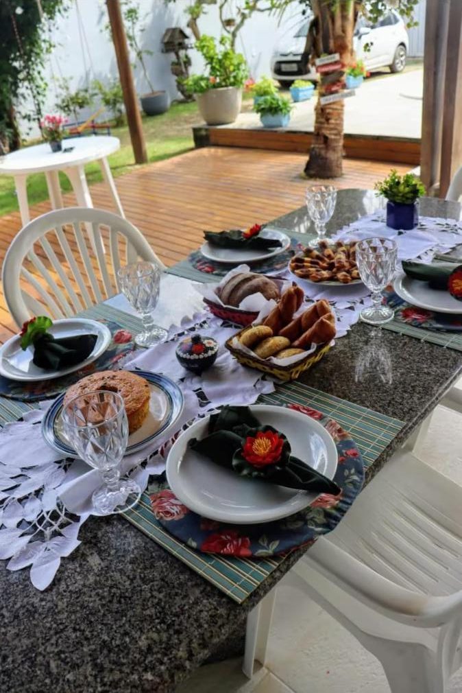 Mesa posta na área externa, com vista para o jardim